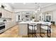 A modern kitchen with a large island with seating and stainless appliances overlooking the living room at 1600 Magnolia Rd, Belleair, FL 33756