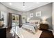 Sunlit bedroom with wood floors, area rug, patio doors, and a ceiling fan at 1600 Magnolia Rd, Belleair, FL 33756