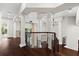 Elegant staircase features dark wood floors, wrought iron railings, and decorative lighting fixtures at 1600 Magnolia Rd, Belleair, FL 33756