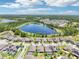 A picturesque aerial view of neighborhood homes situated by a lake with a scenic view under a blue sky at 1741 Cherry Walk Rd, Lutz, FL 33558