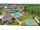 An aerial view features a community pool, tennis court, basketball court, and wooded area at 1741 Cherry Walk Rd, Lutz, FL 33558