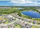 A picturesque aerial view shows the neighborhood near a lake, with modern homes, landscaping and scenic views at 1741 Cherry Walk Rd, Lutz, FL 33558