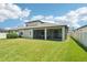 Large backyard with a covered patio and lush green grass at 1741 Cherry Walk Rd, Lutz, FL 33558