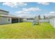Expansive backyard with lush lawn, playset, and privacy fence at 1741 Cherry Walk Rd, Lutz, FL 33558