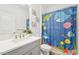 Charming bathroom featuring a vanity, toilet, and shower with ocean-themed curtains at 1741 Cherry Walk Rd, Lutz, FL 33558