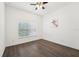 Bright bedroom featuring a ceiling fan, wood-look flooring and a large window at 1741 Cherry Walk Rd, Lutz, FL 33558
