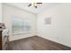 Bright bedroom featuring a ceiling fan, wood-look flooring, and a window at 1741 Cherry Walk Rd, Lutz, FL 33558