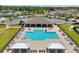 A swimming pool is surrounded by lounge chairs, umbrellas and covered seating areas at 1741 Cherry Walk Rd, Lutz, FL 33558