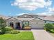 Charming home featuring manicured landscaping, a paver driveway, and a welcoming front porch at 1741 Cherry Walk Rd, Lutz, FL 33558