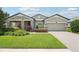 Beautiful front yard with lush green grass, colorful landscaping, and charming exterior of the home at 1741 Cherry Walk Rd, Lutz, FL 33558