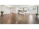 Spacious living room with hardwood floors and modern white kitchen, bathed in natural light at 1741 Cherry Walk Rd, Lutz, FL 33558
