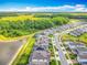 Aerial view of the community showcases houses with solar panels and a serene lake backdrop at 17683 Ramble On Way, Land O Lakes, FL 34638