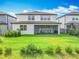 Green backyard featuring a screened lanai, lush green grass, and privacy fence at 17683 Ramble On Way, Land O Lakes, FL 34638