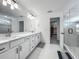 Bathroom features double sinks, a glass-enclosed shower, and a walk-in closet at 17683 Ramble On Way, Land O Lakes, FL 34638