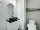 Modern half-bathroom with an oval mirror, vessel sink, and elegant wall decor at 17683 Ramble On Way, Land O Lakes, FL 34638
