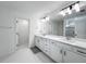 Bathroom boasting double sinks, modern lighting fixtures, and white tiled floors at 17683 Ramble On Way, Land O Lakes, FL 34638