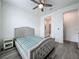 Well-lit bedroom with wood-look flooring, a ceiling fan, and a view to the bath at 17683 Ramble On Way, Land O Lakes, FL 34638