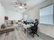 Bright bedroom with gray floors, ceiling fan, and a large desk near a window at 17683 Ramble On Way, Land O Lakes, FL 34638