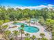 The aerial view showcases a resort-style pool complex with multiple pools, surrounded by lush landscaping at 17683 Ramble On Way, Land O Lakes, FL 34638