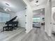 Hallway view with open access to the living room and an office with a black grand piano at 17683 Ramble On Way, Land O Lakes, FL 34638