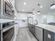 Modern kitchen featuring stainless steel appliances, white cabinets, granite countertops, and a kitchen island at 17683 Ramble On Way, Land O Lakes, FL 34638