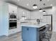 Bright kitchen with white cabinets, a center island with barstool seating, and modern pendant lighting at 17683 Ramble On Way, Land O Lakes, FL 34638