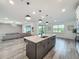 Kitchen island with barstool seating, modern pendant lights, and views of the living area at 17683 Ramble On Way, Land O Lakes, FL 34638