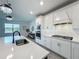 Stylish kitchen with stainless steel appliances, white cabinetry, and a spacious island with a sink at 17683 Ramble On Way, Land O Lakes, FL 34638