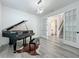 Formal living room with a grand piano, modern light fixture, and beautiful wood-look floors at 17683 Ramble On Way, Land O Lakes, FL 34638