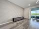 Modern living room with a decorative accent wall, neutral decor, and sliding glass doors to an outdoor patio at 17683 Ramble On Way, Land O Lakes, FL 34638