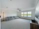 Spacious living room with carpet, ceiling fan, couch, and a view of the water outside the windows at 17683 Ramble On Way, Land O Lakes, FL 34638