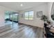 Cozy sitting area with a view of the lake, featuring sliding glass doors and wood-look flooring at 17683 Ramble On Way, Land O Lakes, FL 34638