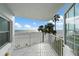 Balcony overlooking a pristine beach with clear, blue skies and swaying palm trees at 17960 Gulf Blvd # 225, Redington Shores, FL 33708