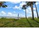 Charming beachfront setup with table, chairs, and umbrella under palm trees, providing a relaxing seaside experience at 17960 Gulf Blvd # 225, Redington Shores, FL 33708