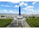 Beachfront patio with outdoor seating and umbrella, perfect for enjoying the stunning ocean views and coastal breeze at 17960 Gulf Blvd # 225, Redington Shores, FL 33708