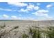 Expansive beach view with clear blue skies and scattered clouds, inviting relaxation and seaside enjoyment at 17960 Gulf Blvd # 225, Redington Shores, FL 33708
