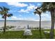Beautiful beach view with palm trees, white sand, and outdoor seating area at 17960 Gulf Blvd # 225, Redington Shores, FL 33708