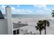 Exterior balcony view with oceanfront, tropical palms, sandy beach and beautiful blue skies at 17960 Gulf Blvd # 225, Redington Shores, FL 33708