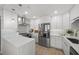 Well-lit kitchen with stainless steel appliances, white cabinets, and stone countertops at 17960 Gulf Blvd # 225, Redington Shores, FL 33708