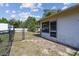 Side view of a home's backyard with chain link fence and mature trees at 2071 Linwood Ave, Spring Hill, FL 34608