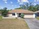 Single story home boasts a neutral exterior, attached garage, and simple landscaping at 2071 Linwood Ave, Spring Hill, FL 34608