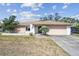 Charming single-story home with a large concrete driveway and an attached garage at 2071 Linwood Ave, Spring Hill, FL 34608