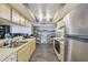 Galley kitchen featuring tile floors, stainless steel appliances, and ample cabinet and counter space at 2071 Linwood Ave, Spring Hill, FL 34608