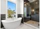Luxury bathroom featuring soaking tub, glass shower, and natural light from a window at 220 Hesperides N St, Tampa, FL 33609