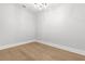 Bright bedroom with hardwood floors, white walls, and modern light fixture at 220 Hesperides N St, Tampa, FL 33609
