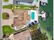 Aerial view of waterfront home with pool, boat dock, and lush landscaping on a sunny day at 2233 Donato Dr, Belleair Beach, FL 33786