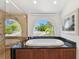 A luxurious soaking tub features an arched window offering a view of the landscape at 2233 Donato Dr, Belleair Beach, FL 33786