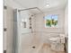 Bathroom with roll-in shower, safety bars, and comfort-height toilet, accessible design at 2233 Donato Dr, Belleair Beach, FL 33786