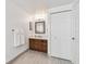 Bathroom with shaker vanity, modern light fixture, and wood-look tile floor at 2233 Donato Dr, Belleair Beach, FL 33786