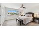 A bright bedroom features a ceiling fan, a window with an exterior view, and laminate floors at 2233 Donato Dr, Belleair Beach, FL 33786
